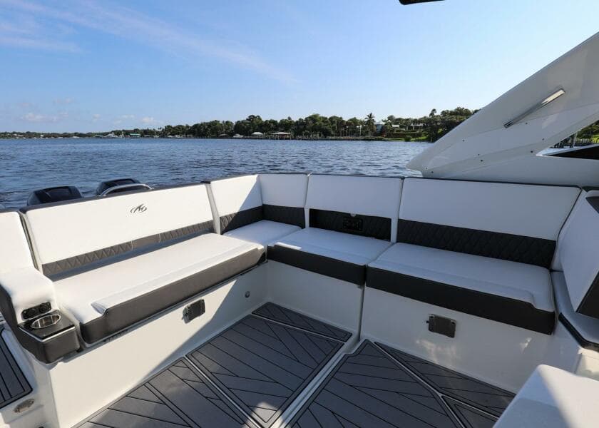2023 Monterey 385 Super Sport boat interior with seating, overlooking a serene water view.