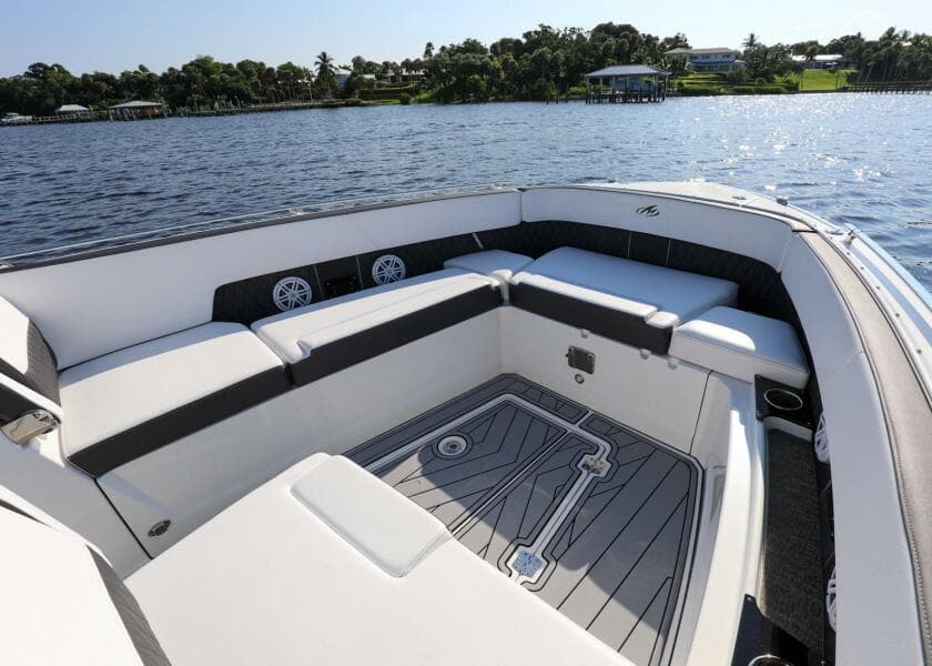 2023 Monterey 385 Super Sport boat interior with spacious seating, on a serene water backdrop.