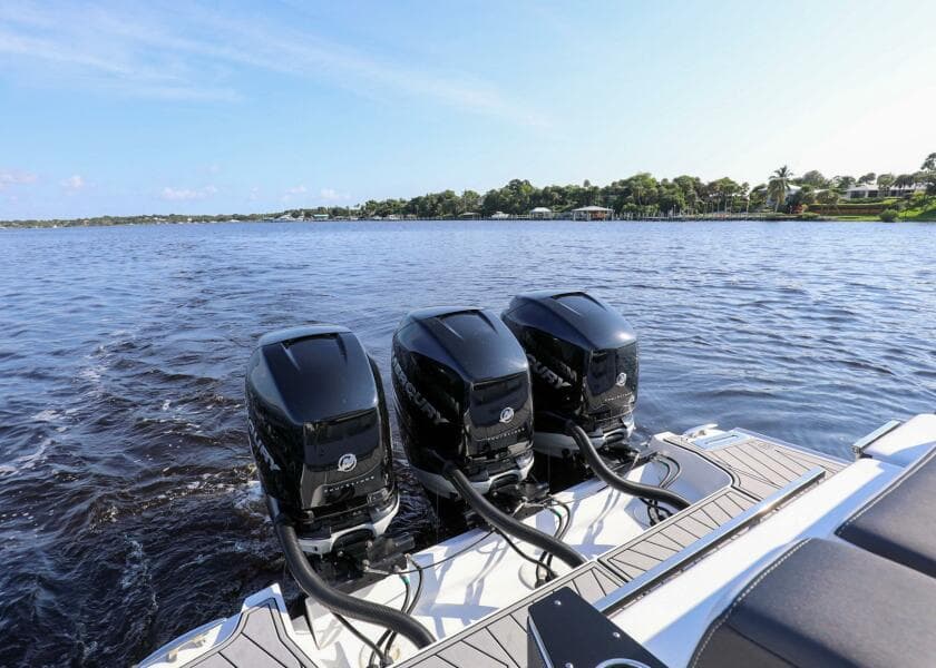 2023 Monterey 385 Super Sport boat with triple outboard engines on a calm lake.