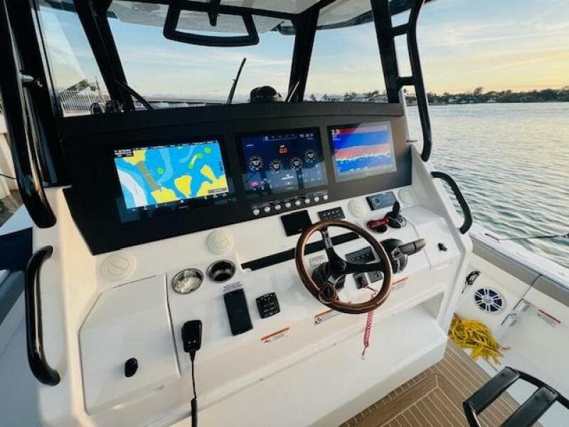 2024 Regulator 41 boat dashboard with advanced navigation screens and controls, overlooking serene waters.