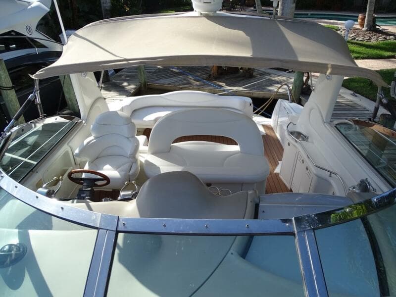2001 Sea Ray 410 Sundancer boat with spacious seating and canopy, docked at marina.