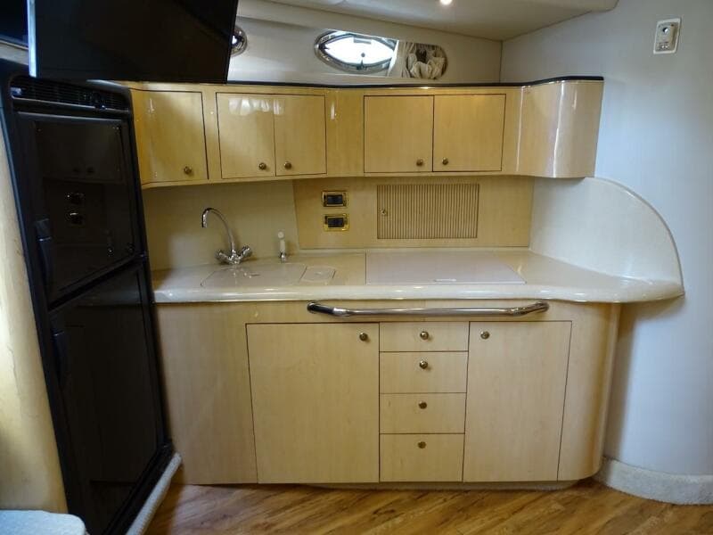 2001 Sea Ray 410 Sundancer kitchen with wooden cabinets and modern appliances.