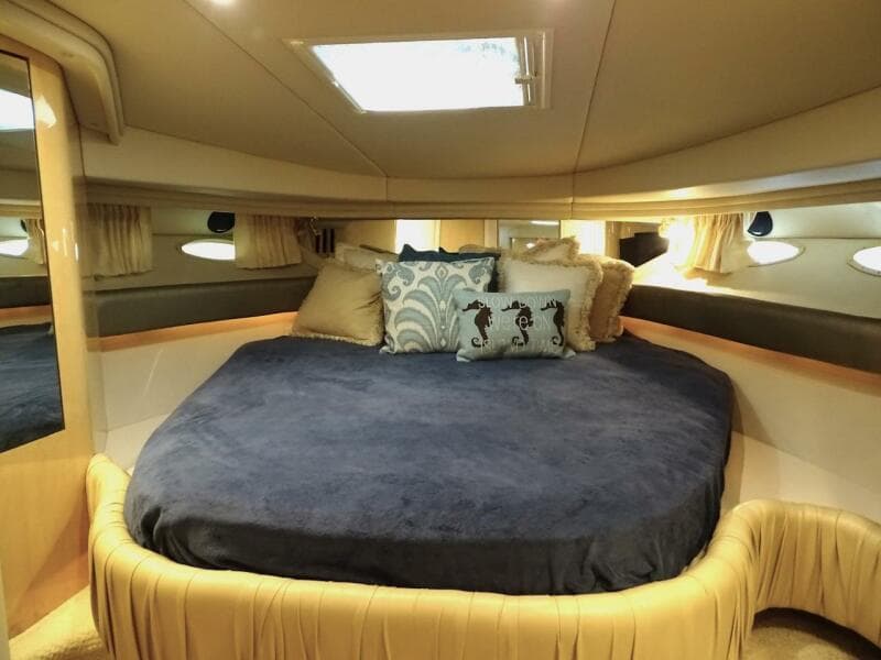 Luxurious cabin interior of 2001 Sea Ray 410 Sundancer yacht with plush bedding.