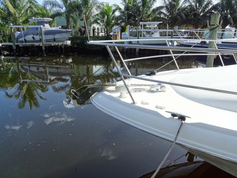 2001 Sea Ray 410 Sundancer yacht docked by palm trees and calm water.