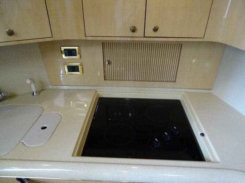 2001 Sea Ray 410 Sundancer kitchen with stove and cabinets.