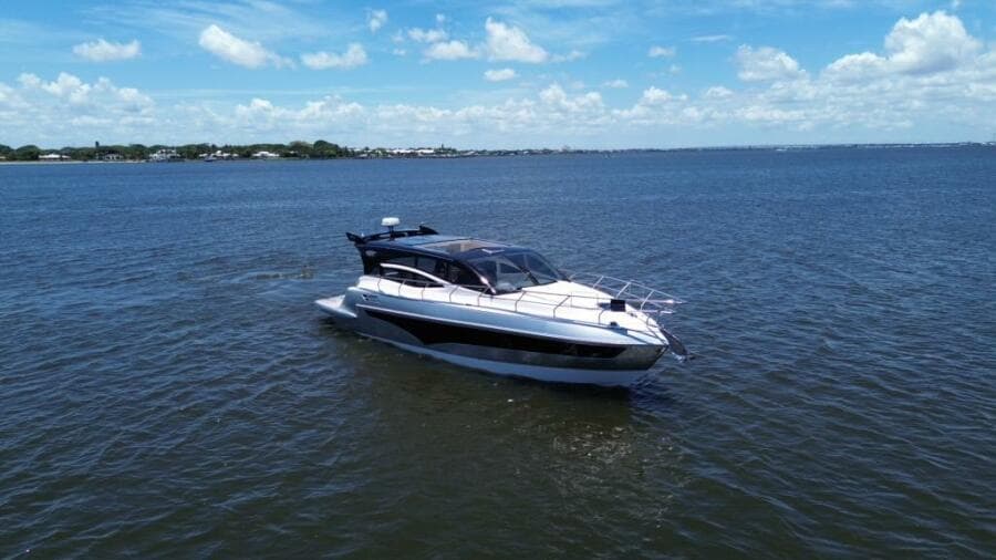 Luxury yacht Real 40 HT 2025 cruising on open water under a clear blue sky.