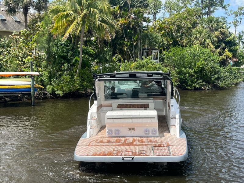 2025 Real 40 HT Luxury boat cruising on a scenic river with lush greenery.