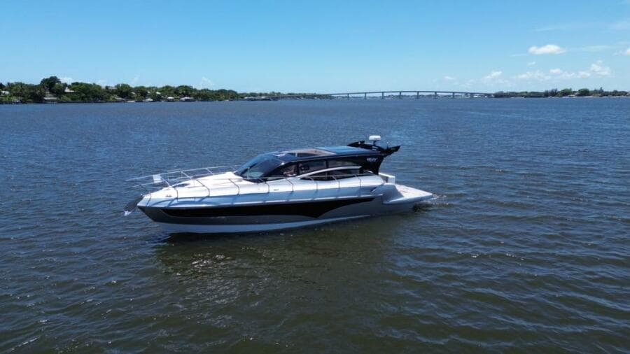 2025 Real 40 HT Luxury yacht cruising on a calm river under a clear blue sky.