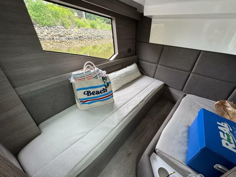 Interior of 2025 Real 40 HT Luxury yacht with beach bag and window view.