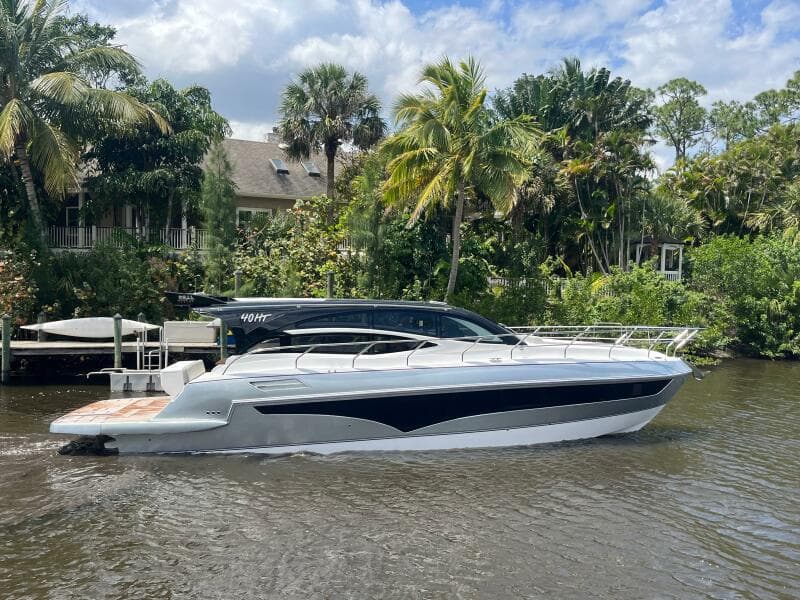 2025 Real 40 HT Luxury yacht cruising on a scenic river with lush greenery.