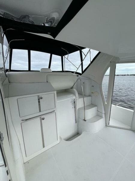 2000 Carver 396 Motor Yacht interior with white cabinetry and steps, overlooking water.