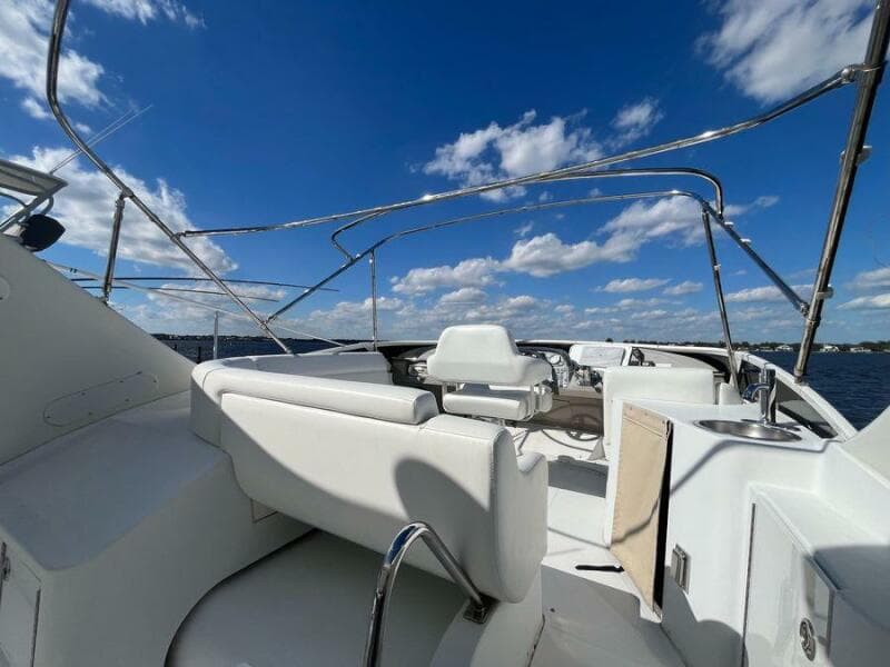 2000 Carver 396 Motor Yacht deck with white seating under a clear blue sky.