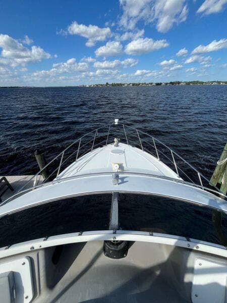 2000 Carver 396 Motor Yacht on open water under a blue sky with clouds.