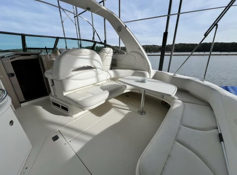 2001 Sea Ray 380 Sundancer yacht interior with white seating and table, overlooking water.