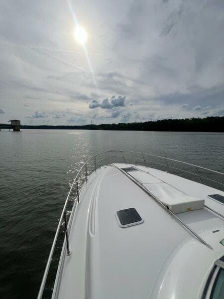 2001 Sea Ray 380 Sundancer cruising on a calm lake under a cloudy sky.