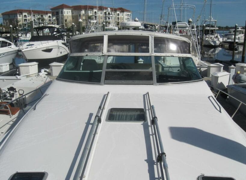 1993 Sea Ray 440 Sundancer yacht docked at marina, surrounded by other boats.