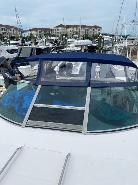 1993 Sea Ray 440 Sundancer docked at marina with blue canopy and nearby buildings.
