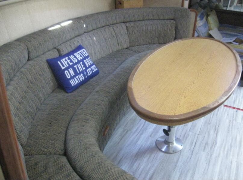 Interior of 1993 Sea Ray 440 Sundancer with curved seating and wooden table.