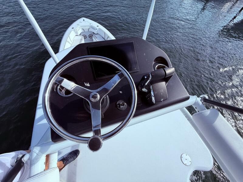 2024 Contender 39 ST boat helm with steering wheel and controls, overlooking water.