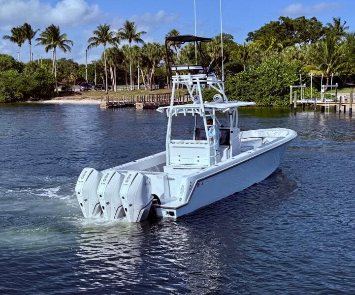 2024 Contender 39 ST boat with triple engines cruising on a tropical waterway.