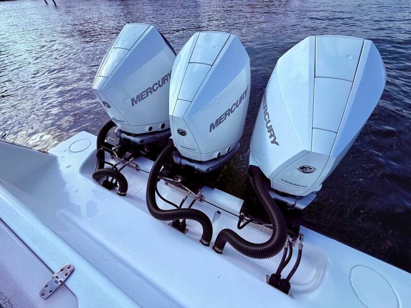 Triple Mercury outboard engines on 2024 Contender 39 ST boat, docked on water.