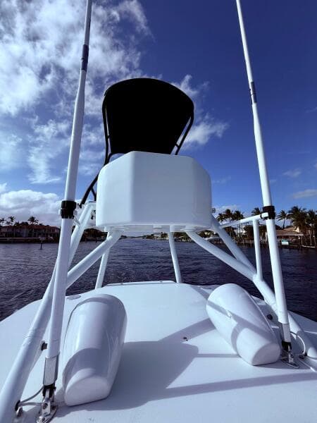 2024 Contender 39 ST boat with tower against a blue sky and waterfront view.
