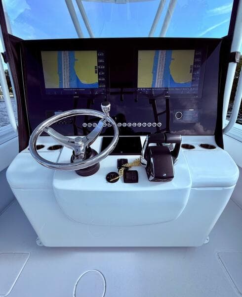 2024 Contender 39 ST boat dashboard with dual navigation screens and steering wheel.