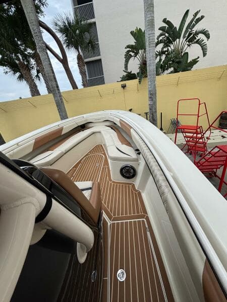 2013 Statement 35 Center Console boat with sleek deck and seating, surrounded by tropical plants.