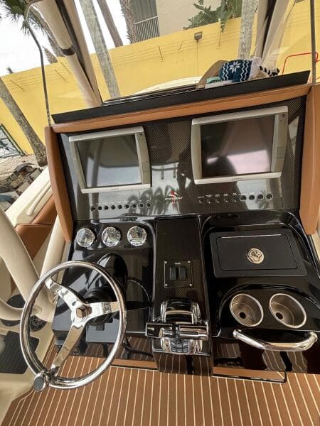 Control panel of a 2013 Statement 35 Center Console boat with dual screens and steering wheel.