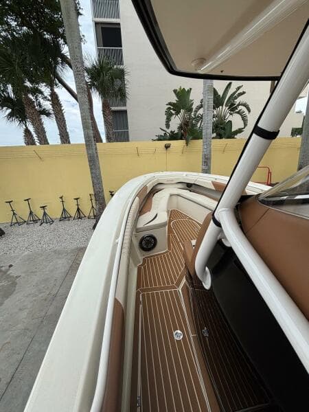 2013 Statement 35 Center Console boat with sleek interior and wood accents, docked near palm trees.