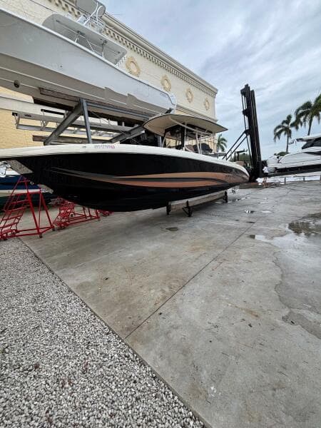 2013 Statement 35 Center Console boat on dry dock, with overcast sky and palm trees.