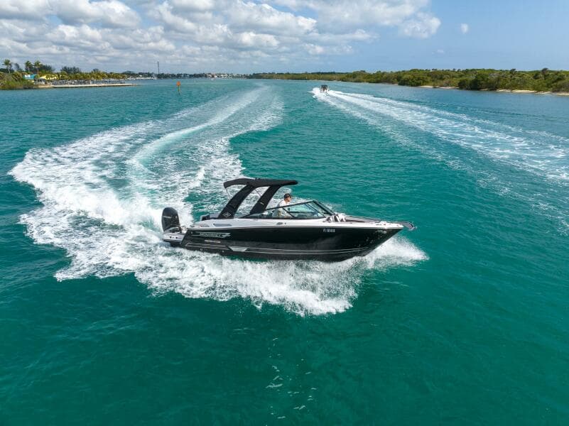 2023 Monterey 255 Super Sport boat cruising on clear blue water under a partly cloudy sky.