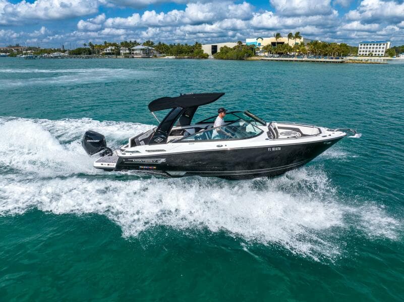 2023 Monterey 255 Super Sport boat cruising on turquoise water under a partly cloudy sky.