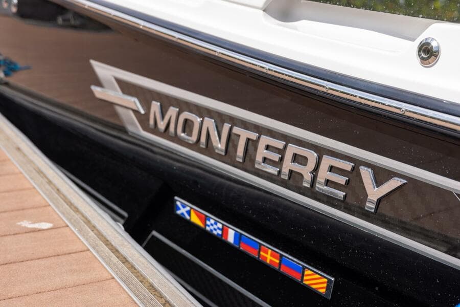 2023 Monterey 255 Super Sport boat with logo and nautical flags.