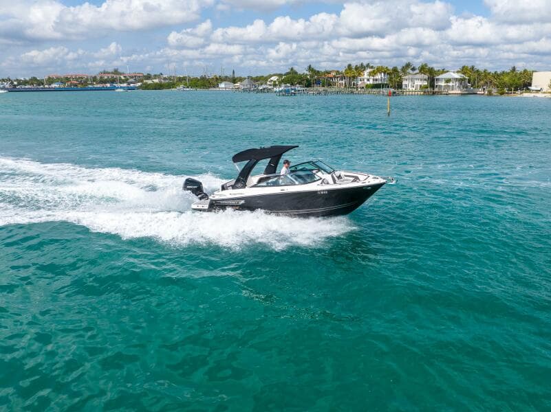 2023 Monterey 255 Super Sport boat cruising on turquoise water under a partly cloudy sky.