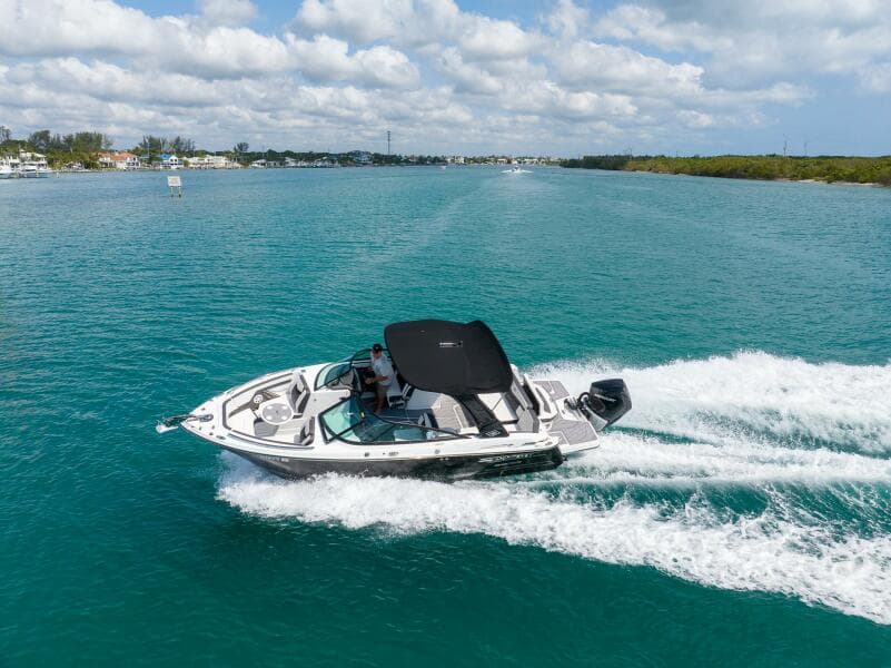 2023 Monterey 255 Super Sport boat cruising on clear blue water under a partly cloudy sky.