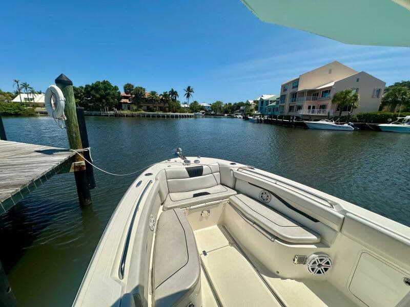 2019 Wellcraft 262 Fisherman boat docked in a scenic waterfront area.