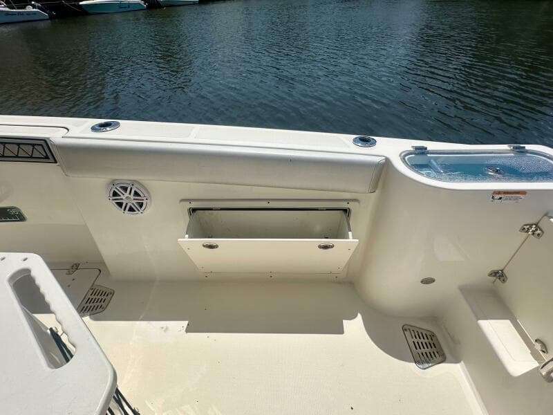 2019 Wellcraft 262 Fisherman boat interior with storage compartment and water view.