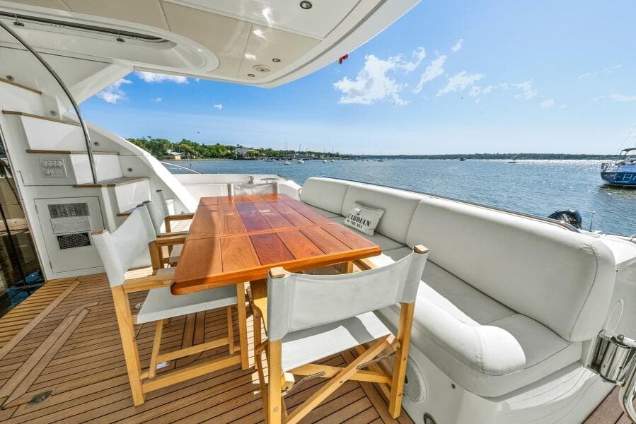 Luxurious Sunseeker Manhattan 65 yacht deck with seating, table, and scenic water view.