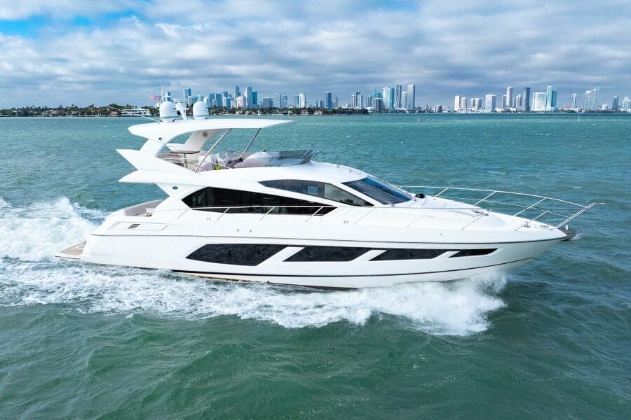 2016 Sunseeker Manhattan 65 yacht cruising on open water with city skyline backdrop.