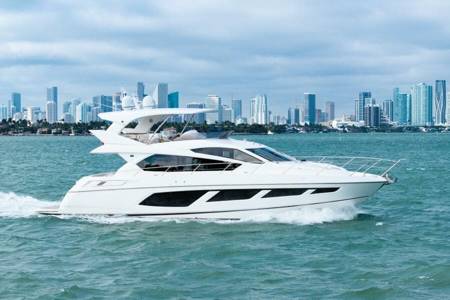 2016 Sunseeker Manhattan 65 yacht cruising with city skyline in the background.