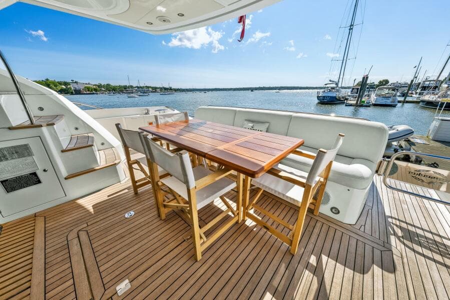 Luxury Sunseeker Manhattan 65 yacht deck with dining area, 2016 model, overlooking marina.