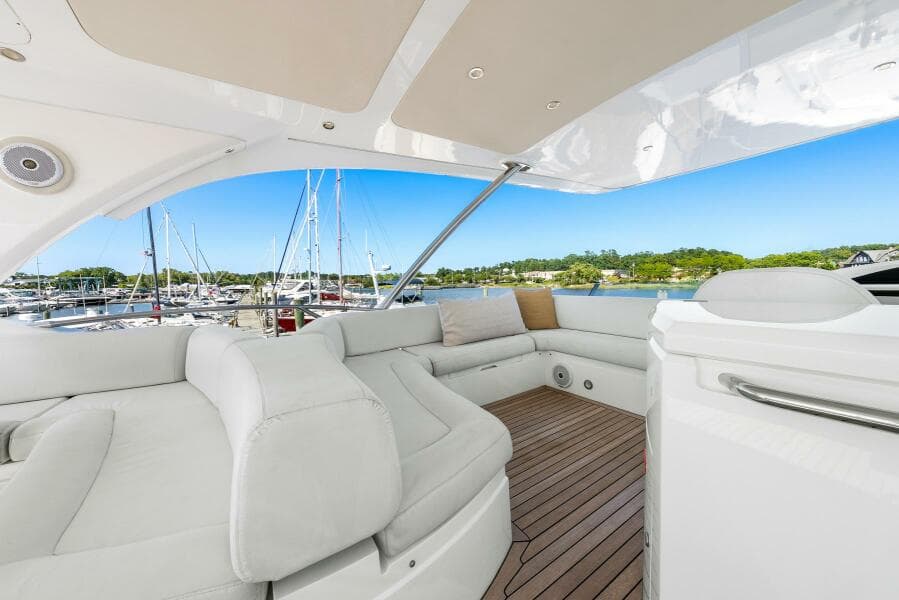 Luxurious 2016 Sunseeker Manhattan 65 yacht interior with white seating and wooden deck.