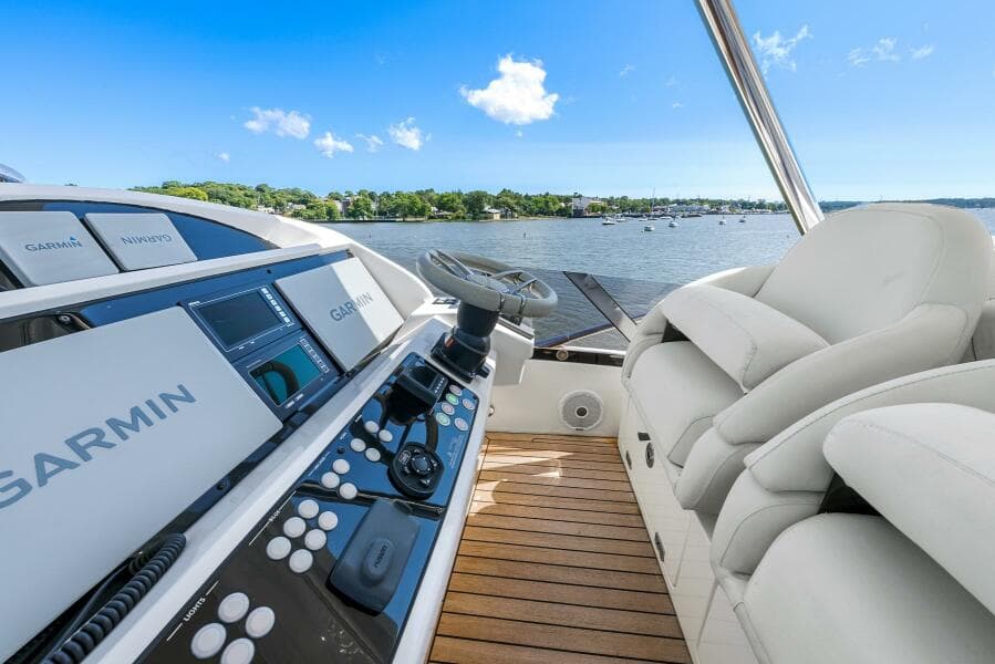 2016 Sunseeker Manhattan 65 yacht helm with Garmin navigation, overlooking serene waters.