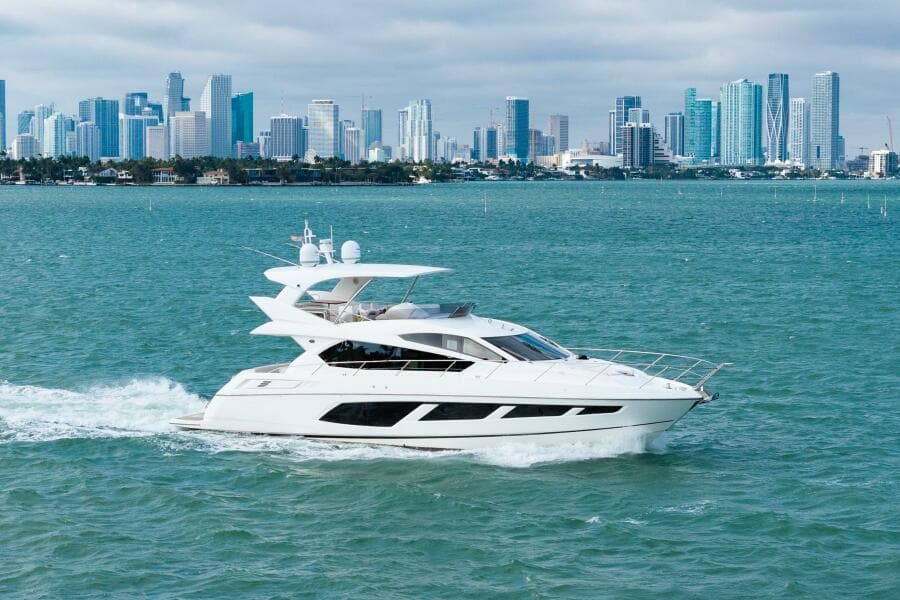 2016 Sunseeker Manhattan 65 yacht cruising with city skyline backdrop.