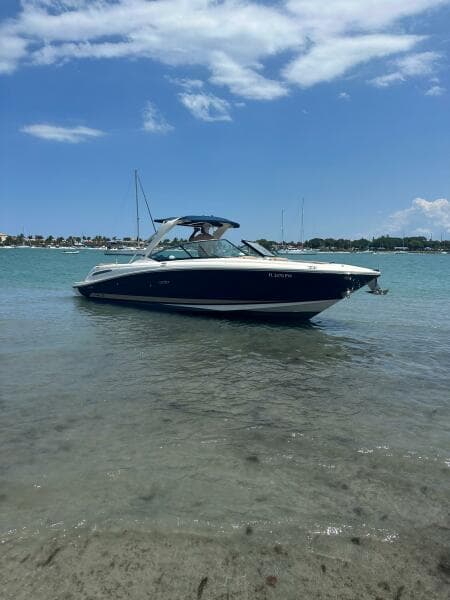 2014 Sea Ray 270 SLX boat on calm water under a clear blue sky.