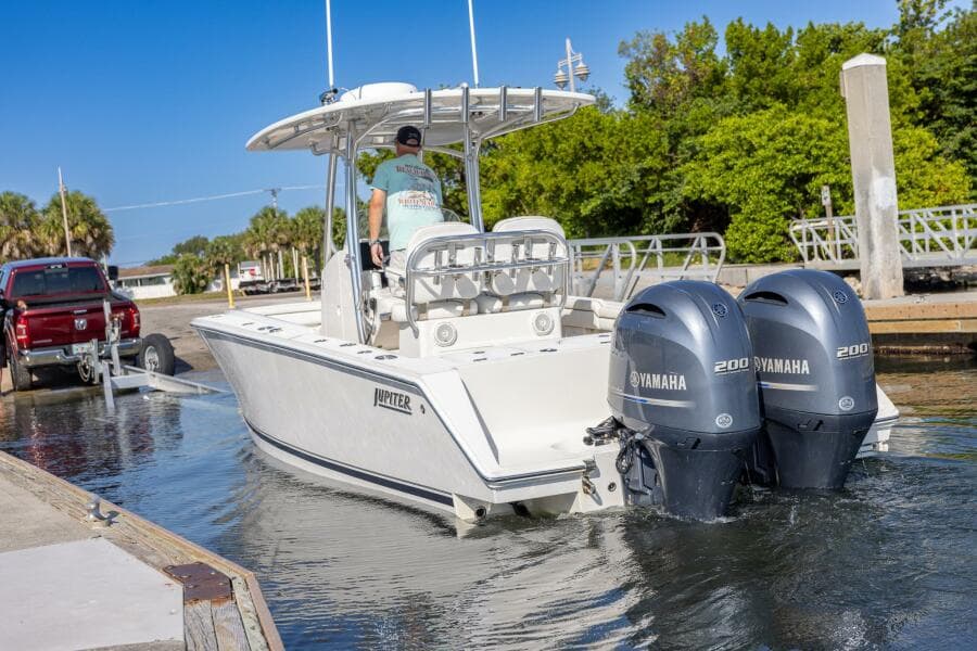 2018 Jupiter 26 FS boat with dual Yamaha engines launching from a dock.