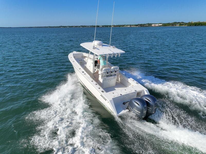 2018 Jupiter 26 FS boat cruising on open water with twin engines.