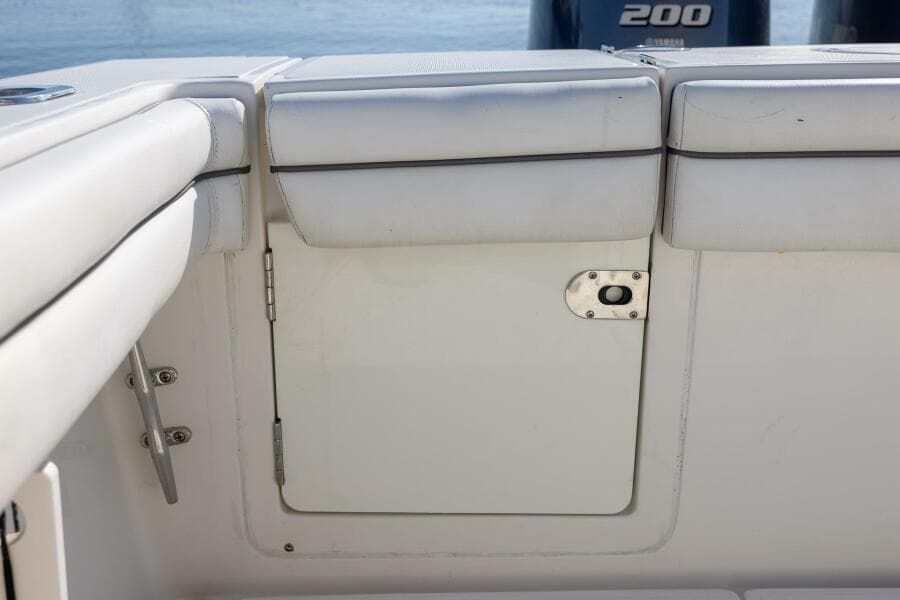 2018 Jupiter 26 FS boat interior with white cushioned seating and storage compartment.
