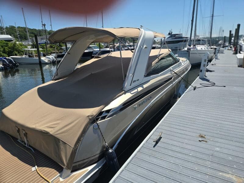 2015 Formula 330 Crossover Bowrider docked at marina with beige cover.